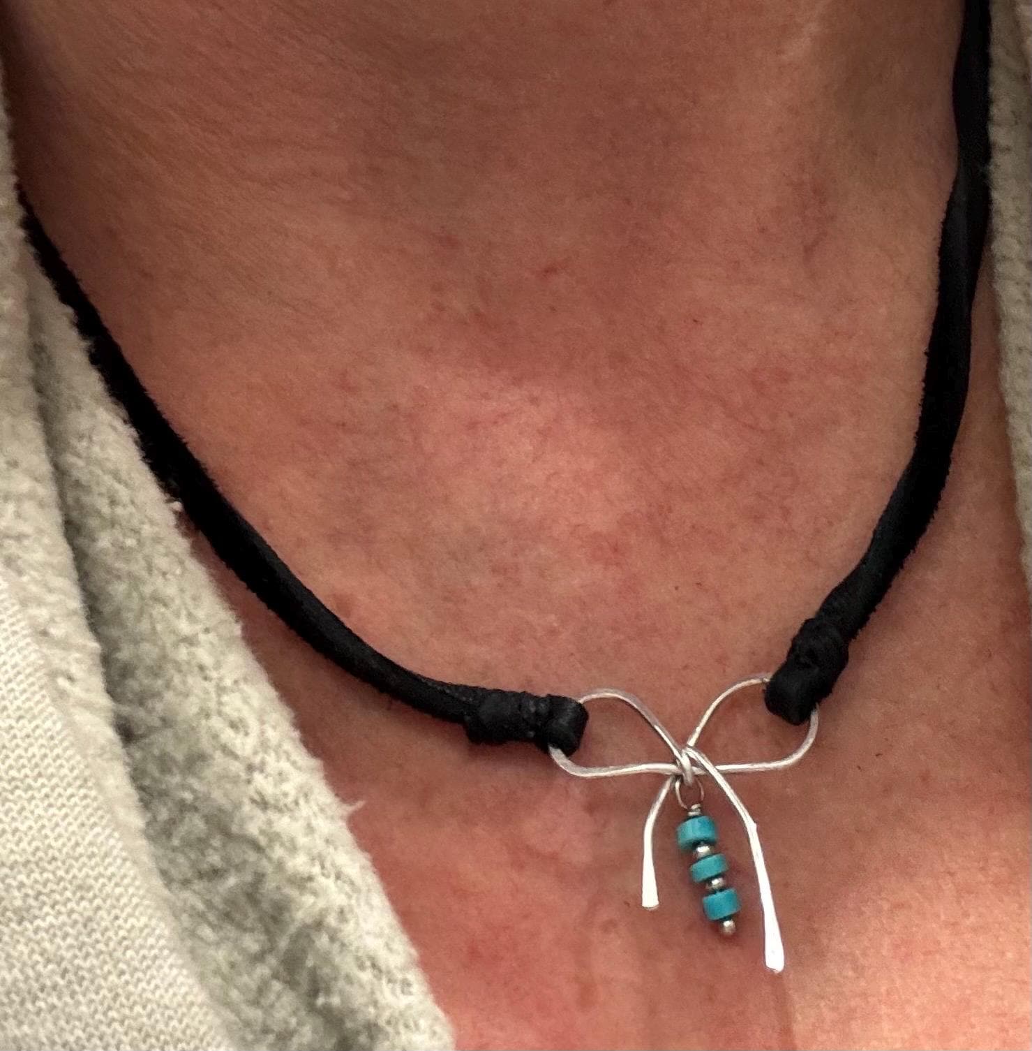 Dainty little silver handmade bow on genuine deerskin single leather lace with turquoise dangle