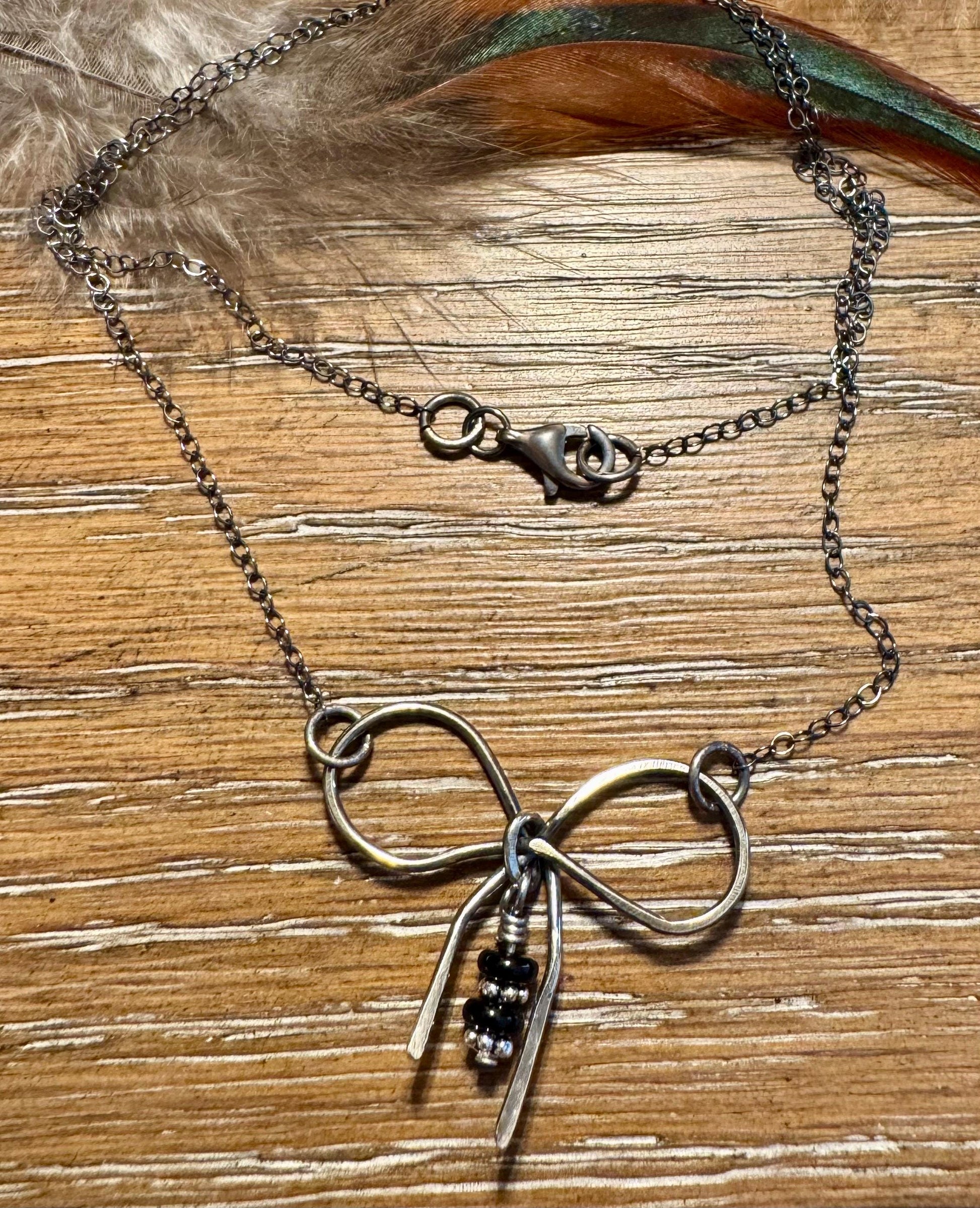 Sterling silver oxidized small bow necklace with black onyx and sterling flower spacers